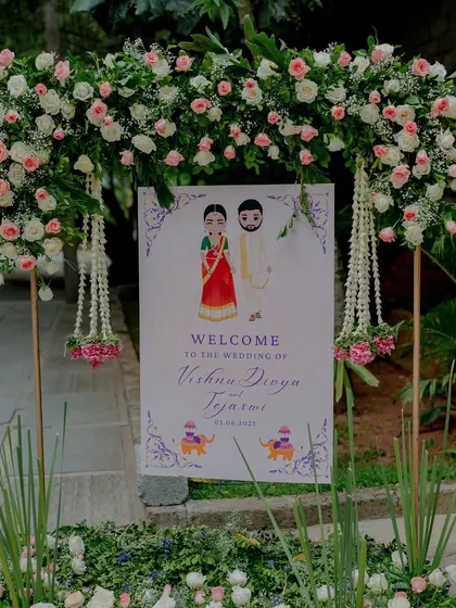 A personalized welcome sign for a wedding, framed by a beautiful floral arch.