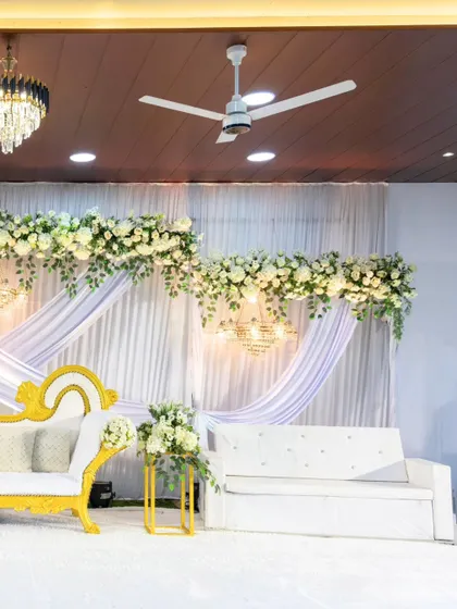 For Aksa and Swanish's engagement, we designed a clean and elegant stage with white drapes, white florals, and a touch of gold in the furniture, creating a timeless and sophisticated look.
