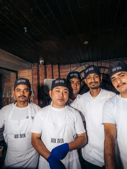 The crew. This is part of the dedicated team that brings the fire every day, crafting your favorite pizzas with skill and passion.