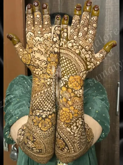 A bride showcasing her intricate floral mehendi, which features a unique reverse-fill technique for a bold look.