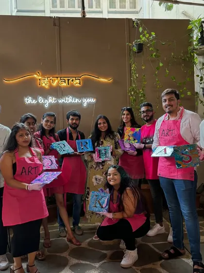 A group from a fluid art party, each holding a unique initial they created. The results of fluid art are always a fun surprise.