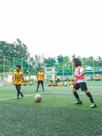 A coach observes a training match, clipboard in hand. We constantly assess player performance to provide targeted feedback and track progress throughout their development journey.