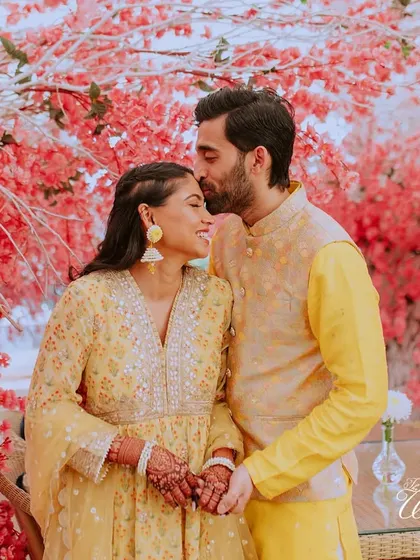 A beautiful portrait against a stunning cherry blossom backdrop, the groom's tender forehead kiss says it all.