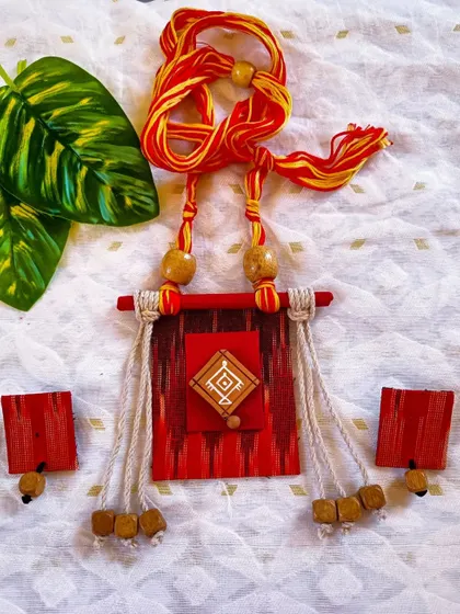 An Ikat-inspired fabric necklace with wooden beads and jute tassels. This piece has a rustic, earthy feel and is perfect for lovers of handloom and natural textures.