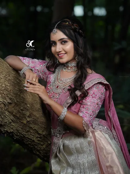 An elegant outdoor portrait in a half-saree. The natural setting and the model's graceful pose create a beautiful, almost painterly image.
