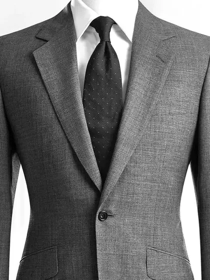 A close-up of a classic charcoal grey suit. The texture of the fabric and the perfect fit of the lapel are hallmarks of our quality tailoring.