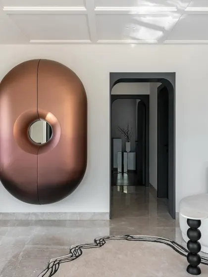 The sculptural bar unit in the Evelyn lounge, seen here closed. Its unique shape and ombre finish make it a piece of art on the wall, demonstrating how functional items can also be beautiful.