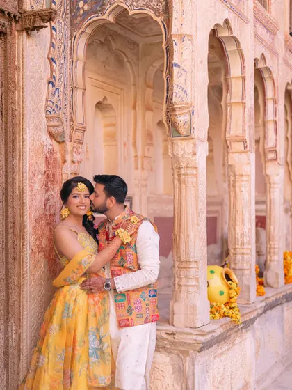 An intimate moment shared between the couple against the backdrop of ancient archways and pillars, showcasing the romantic architecture of their venue.