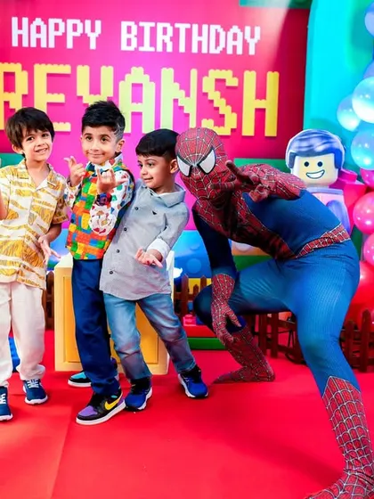 Spider-Man strikes a pose with the birthday boy and his friends at a LEGO-themed party, creating a super photo opportunity.