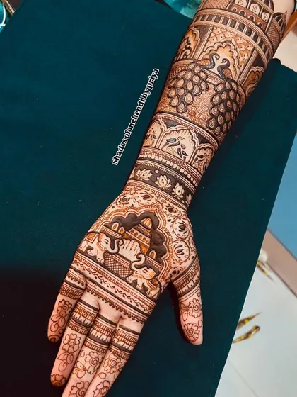 Close-up of the right hand from the engagement set, featuring elephant motifs and detailed architectural patterns.