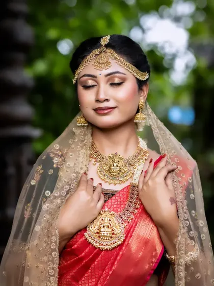 A serene moment captured, showing the intricate details of the matha patti and layered necklaces. This is a classic look for any traditional South Indian bride.