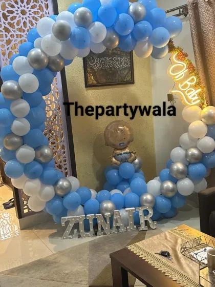 A 'Welcome Home' decoration for a baby boy, with a blue and white balloon ring and a baby foil balloon.