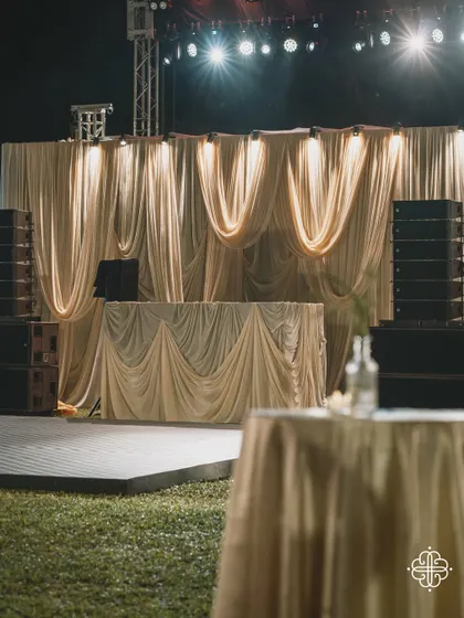 The DJ console and stage for a Goa celebration, draped in elegant, flowing fabrics.