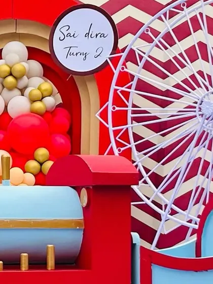 Details of the carnival decor, including a miniature ferris wheel and a custom sign for the second birthday celebration.