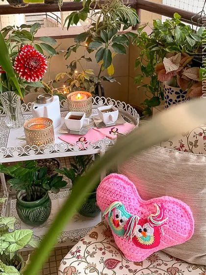 A Valentine's Day special. This pink heart-shaped cushion with two little owls is perfect for a romantic and whimsical balcony setup.