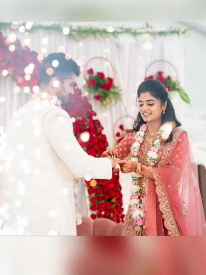 The couple exchanges rings in front of our elegant engagement decor, with soft lighting and rich red floral arrangements creating a warm and celebratory atmosphere.