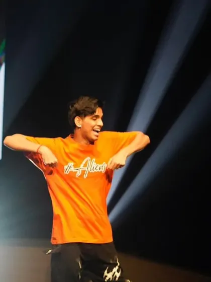 A close-up of one of our hip hop dancers, feeling the beat and giving his all under the bright stage lights.