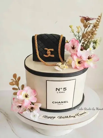 A chic Chanel themed cake for a fashion lover. This design features the iconic quilted bag and No. 5 perfume bottle, adorned with delicate flowers.