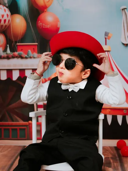Too cool for two. This little guy is rocking his shades and his second birthday carnival theme with style.