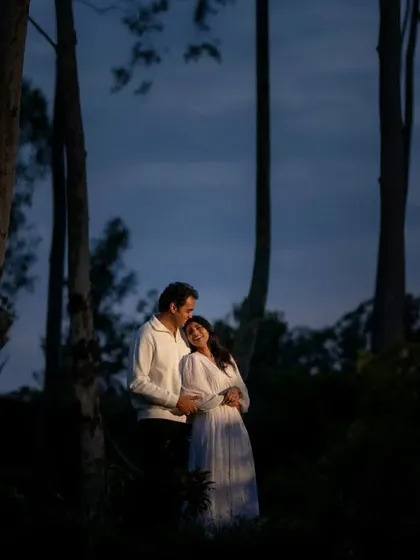 A romantic embrace in the woods after sunset. The deep blue of the twilight sky and the intimacy of the pose create a quiet, moody, and beautiful pre-wedding portrait.