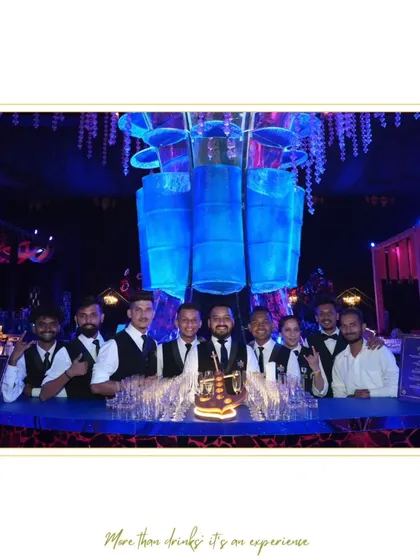 Our team assembled behind a dramatic, blue-lit bar, ready to manage a large and energetic wedding reception.