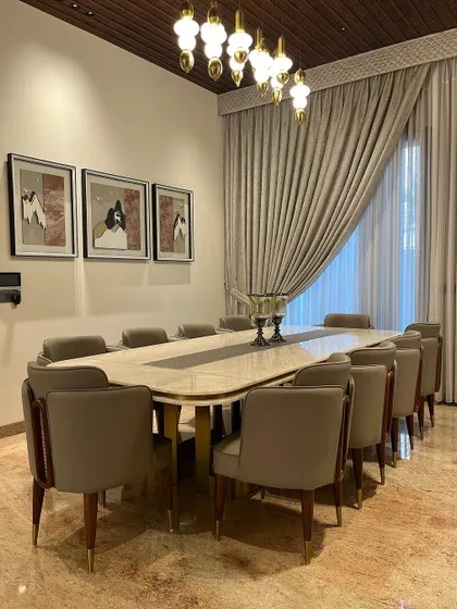 This grand 10-seater dining table was crafted for a client in Ambala. The expansive marble top and elegantly upholstered chairs are set under a rich wooden ceiling, creating a luxurious and welcoming space for large family gatherings and celebrations.
