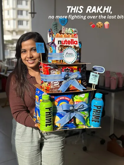 Here I am with our epic Rakhi Food Tower Hamper! I designed this so there’s no more fighting over the last bite. It’s stacked high with all the snacks and chocolates that celebrate the sweet and salty nok-jhok of the sibling bond.