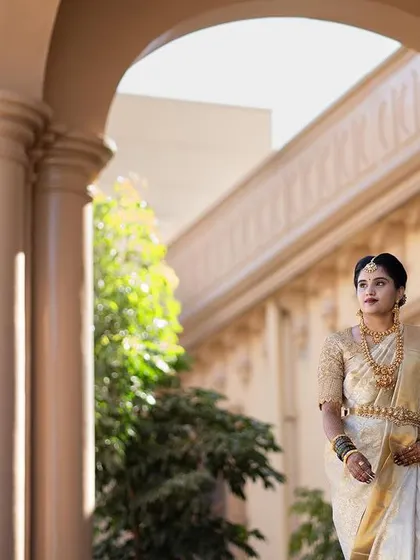 A full portrait of the bride on her wedding day. The makeup is designed to be timeless, pairing perfectly with her traditional white Kanchivaram saree, temple jewellery, and elegant hair bun.