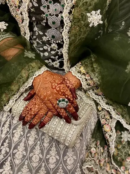 The deep red henna stain looks so elegant against this bride's beautiful green and silver outfit. It shows how the mehendi becomes a key part of your overall bridal look.