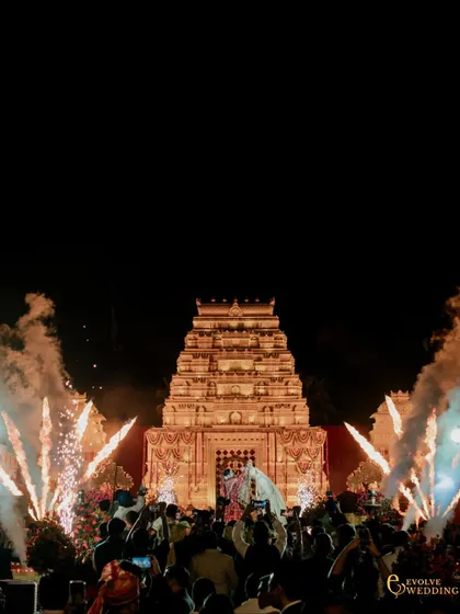 A dramatic moment as pyrotechnics frame the temple mandap during the wedding ceremony. This shot captures the fusion of sacred architecture and celebratory spectacle, creating a truly memorable experience.