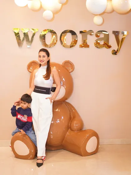 A stylish photo of a client and her son in front of our signature Wooray sign, a popular spot for party pictures.