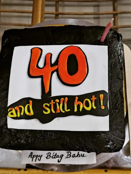 A fun and cheeky cake for a 40th birthday that reads "40 and still hot!".