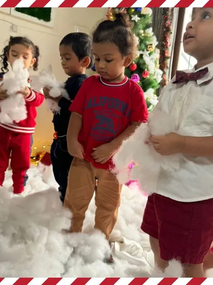 Toddlers curiously touching the soft cotton "snow." Our celebrations are full of sensory exploration.