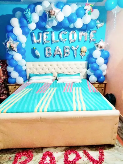 A straight-on shot of the blue and white 'Welcome Baby' balloon arch, accented with star-shaped foil balloons and baby-themed cutouts.