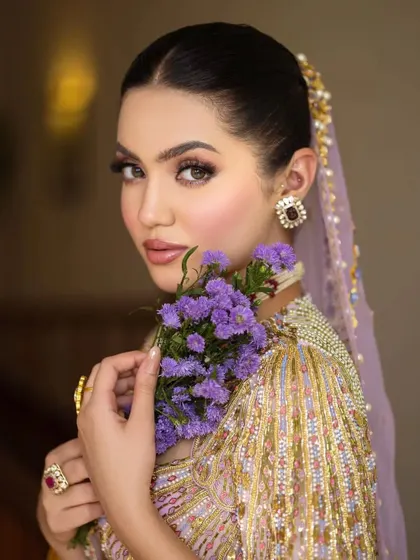 A beautiful portrait showcasing the bride's serene expression and the intricate beadwork on the unique blouse design.