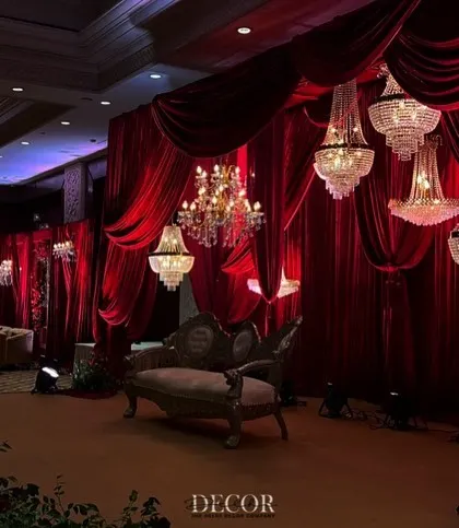 A wider view of the reception stage, showing how the elements come together. The arrangement of chandeliers and the elegant vintage sofa create a balanced and visually stunning composition.
