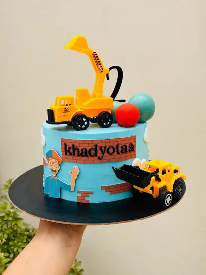 A fun Blippi-themed cake for a second birthday. The design includes toy construction vehicles and a friendly Blippi character, perfect for curious toddlers.