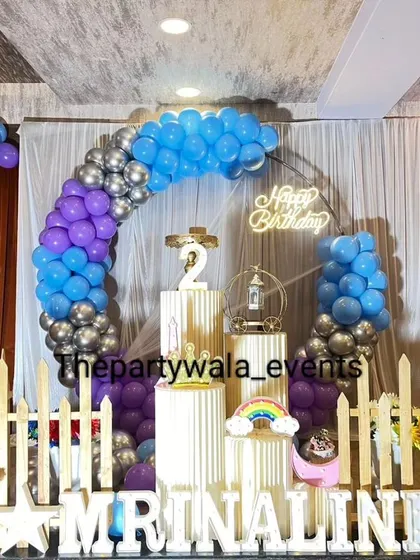 A blue, purple, and silver balloon arch, creating a cool-toned and modern look.
