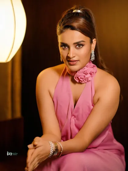 A close-up portrait focusing on beauty and elegance. The soft lighting and pink halter dress create a sophisticated and polished look, perfect for a beauty or jewelry campaign.