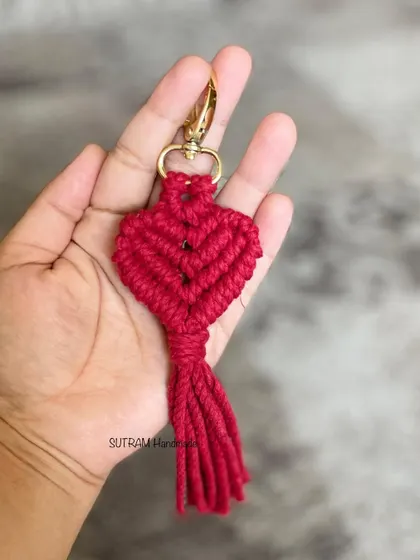 Close up of a single red heart keychain, showing the intricate knot work.