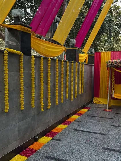 A closer view of the decorated swing and marigold wall hangings, perfect for a daytime mehndi or haldi function at home.
