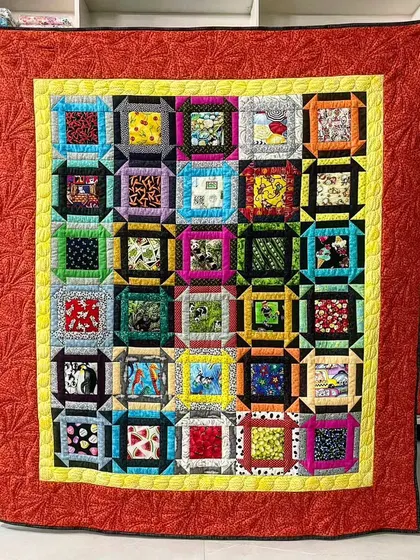 A colorful quilt with a "window frame" or "I-Spy" style, perfect for using a variety of fun, novelty fabrics.