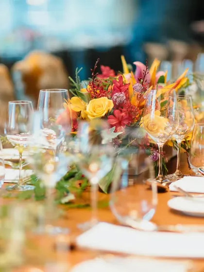 A beautifully set table with a vibrant floral centerpiece and elegant glassware. The soft focus captures the warm, inviting ambiance we strive to create for every sit-down meal.