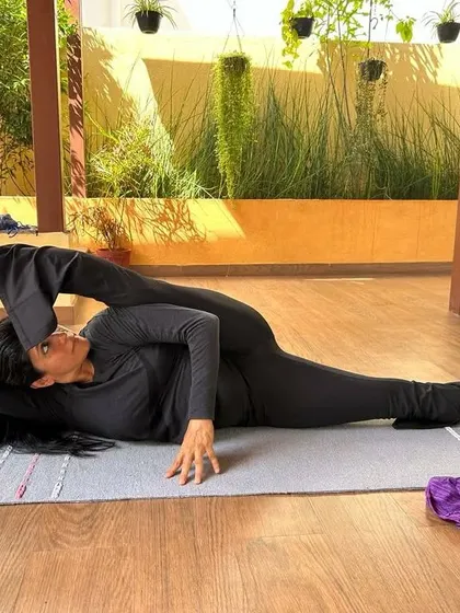 This is an advanced hip-opening and spinal twist posture, Yoganidrasana. It requires significant flexibility in the hips and spine. Such asanas are a testament to what consistent and dedicated practice can achieve.
