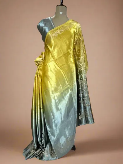 A unique shaded satin crepe saree with a flamingo border, blending from yellow to grey.