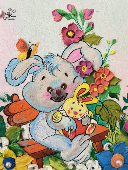 A close-up of the painted bunny and sculpted flowers from the baby handprint restoration project.