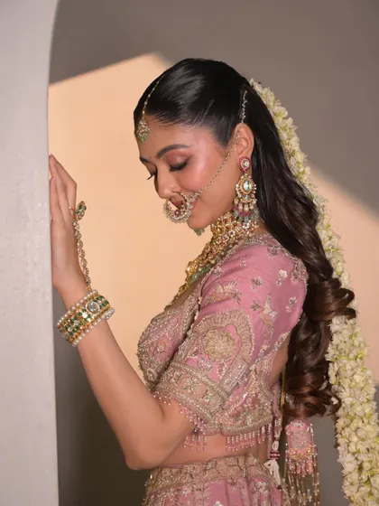 A side profile showing the elegant hairstyle and the soft, glowing makeup. The look is polished and perfect from every angle.