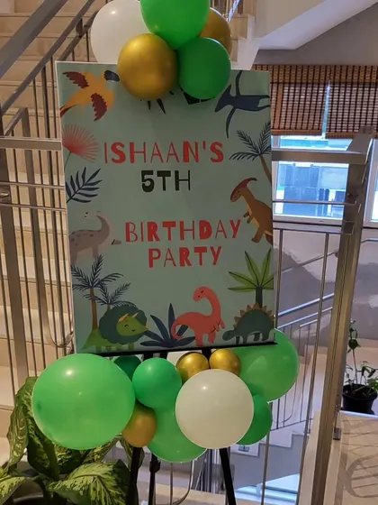 A custom welcome sign for the dinosaur party, decorated with balloons.