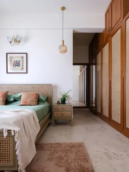 A view of the master bedroom's rattan wardrobe and bed, which create a simple yet contemporary aesthetic. The design focuses on natural materials and a soothing color palette.