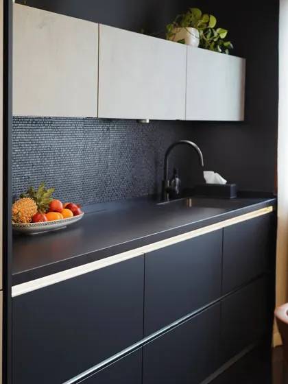 This view highlights the secondary prep area in the Mibu Residence kitchen. The combination of a dark mosaic backsplash and under-cabinet lighting creates a functional and atmospheric workspace.